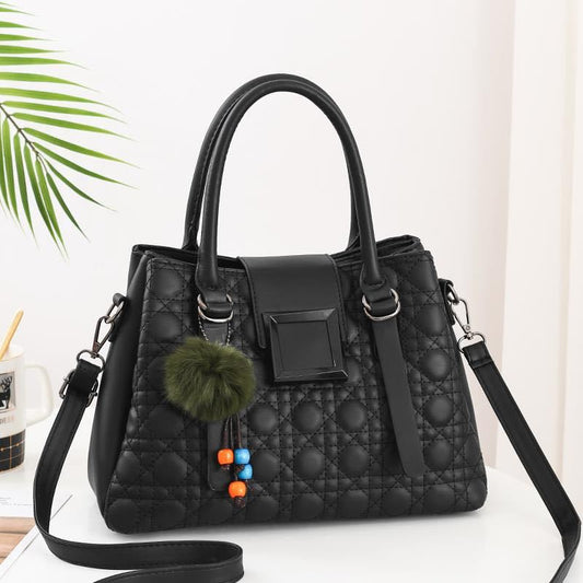 A black PU leather shoulder crossbody bag with a quilted design, featuring a polyester cotton lining, a zipper buckle, and a car suture detail. The bag has a horizontal square shape and includes a detachable strap and a decorative pom-pom.