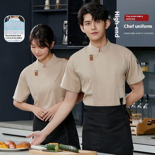 Two models wearing beige chef uniforms with short sleeves, male in front and female behind, standing in a kitchen setting with various ingredients displayed on the counter.