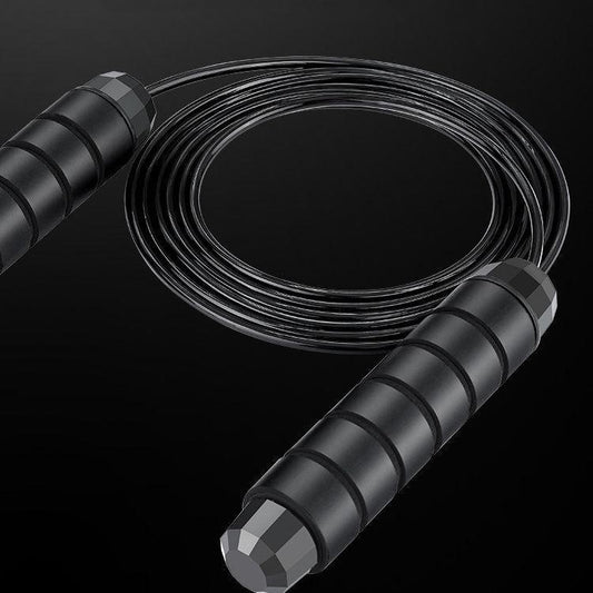 A black jump rope with foam handles and a steel wire rope.