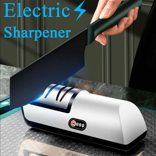 An electric knife sharpener in white and black colors, with a knife being sharpened by it, against a kitchen background.