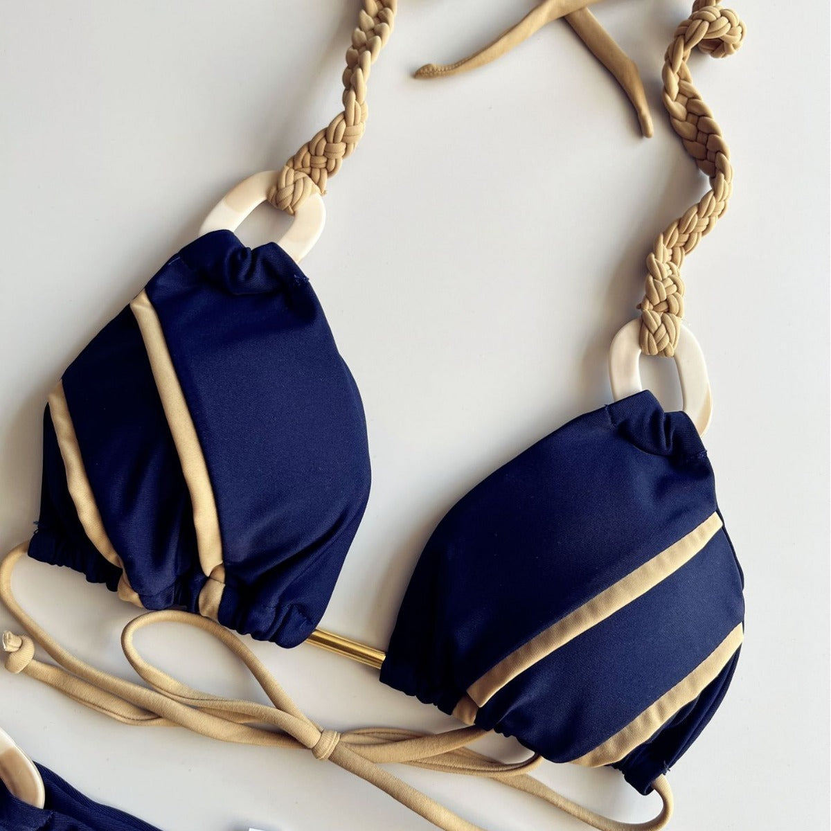 Navy blue bikini with beige straps on a white background