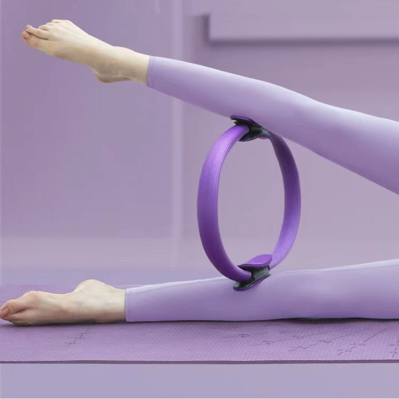 Person using a purple Pilates ring on a mat.