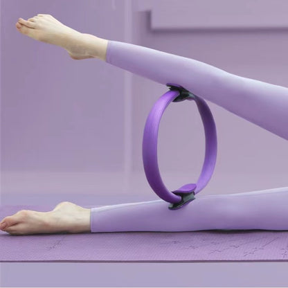 Person using a purple Pilates ring on a mat.