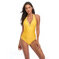 A woman wearing a red halterneck one-piece swimsuit with lace-up details at the front.