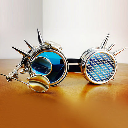 A pair of blue tinted goggles with silver metal frames and spike decorations on the sides.