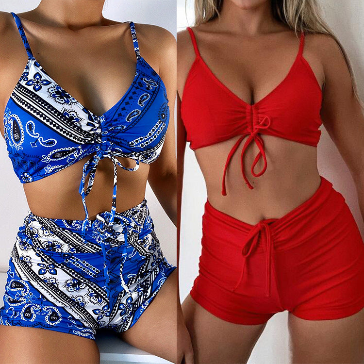 Two swimsuits, one with a blue paisley pattern and the other in red with a tie-top and high-waisted bottoms.