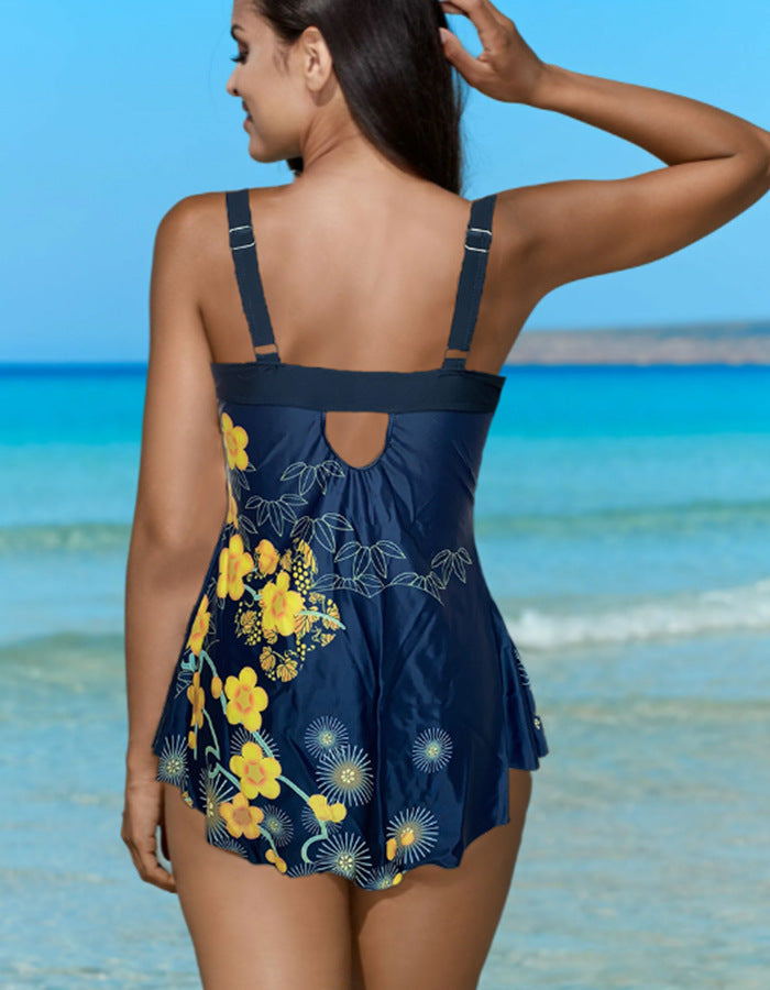 Woman wearing a blue floral swimsuit on a beach.