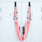 A person using a purple yoga inversion and stretching strap to assist with a yoga pose, hanging from a door frame.