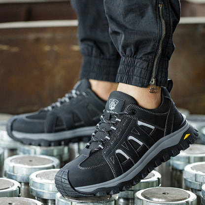 A pair of black, lace-up protective footwear designed for men, featuring a deodorant toe cap and lightweight design, placed on metal surfaces.
