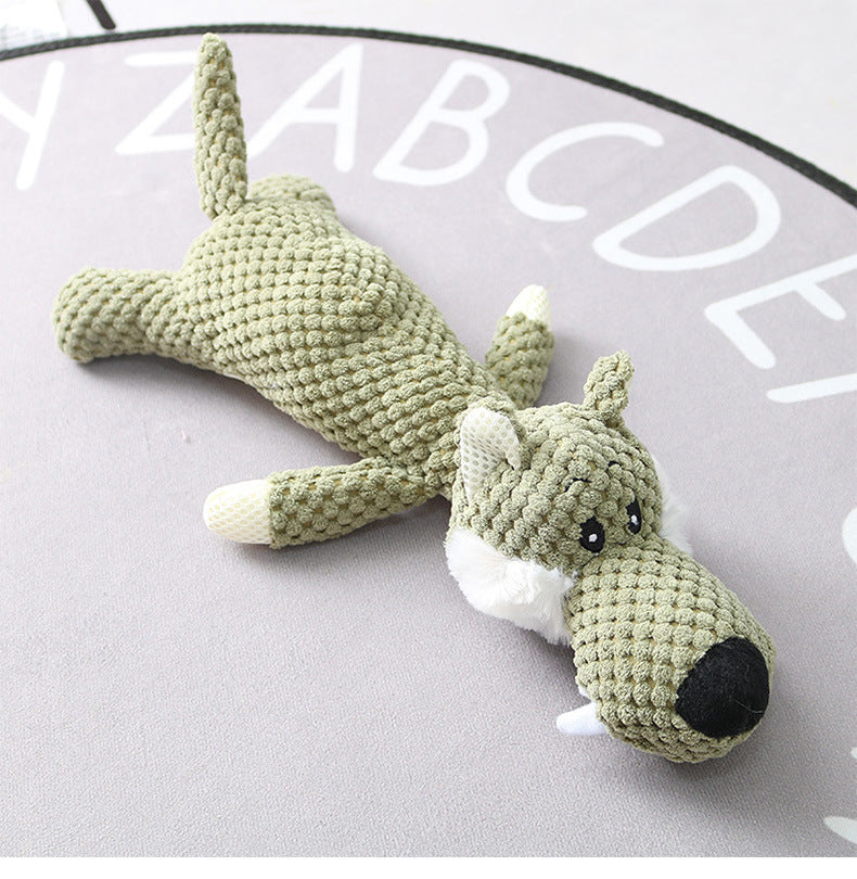 Crocheted dog toy on a gray surface with alphabet letters.