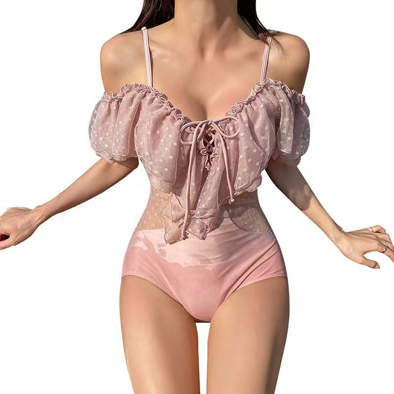 Pink satin bodysuit with lace-up details on a white background