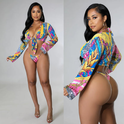 A model wearing a colorful floral print lace-up bikini with a long-sleeve cover-up.
